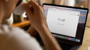 Someone looks at a laptop with Google displayed.