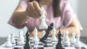 Woman playing chess checks the queen.