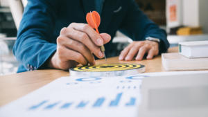 Businessman sits at desk with papers to identify target audience
