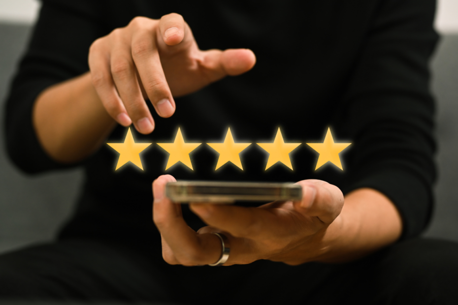 A man holding a phone with 5 stars coming out of it.