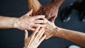 5 diverse hands gathering together in a show of support